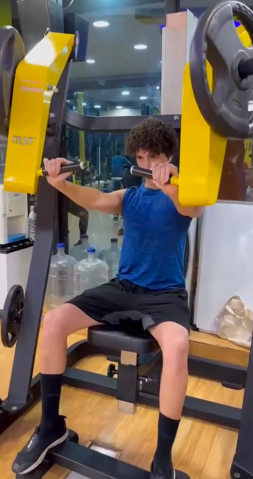 Member performing a seated shoulder press machine